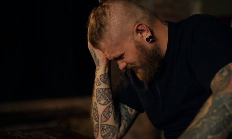 momak se drži za glavu od bola