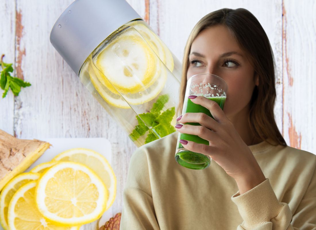 devojka pije sok od celera u žutoj majici, u pozadini detoks organizma za jedan dan, flašica sa limunom, nanom i vodom